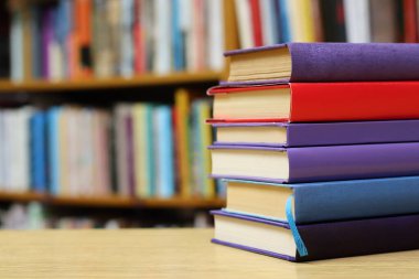 Kütüphanedeki masanın üzerinde kitap yığını