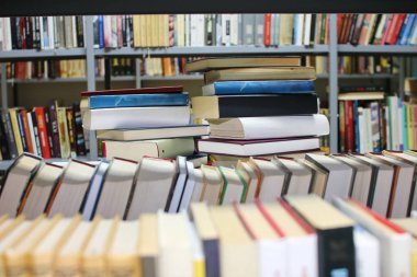 Kütüphanedeki masanın üzerinde kitap yığını