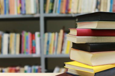 Kütüphanedeki masanın üzerinde kitap yığını