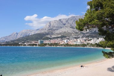 Makarska, Hırvatistan, 18 Nisan 2022. Bu yıl Paskalya tatilini Makarska 'da geçiren ilk turistler, kumsalda güneşlenmenin keyfini çıkarıyorlar.