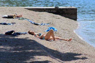 Makarska, Hırvatistan, 12,05,2022. Turistler deniz kıyısındaki güneşli havanın tadını çıkarırlar.