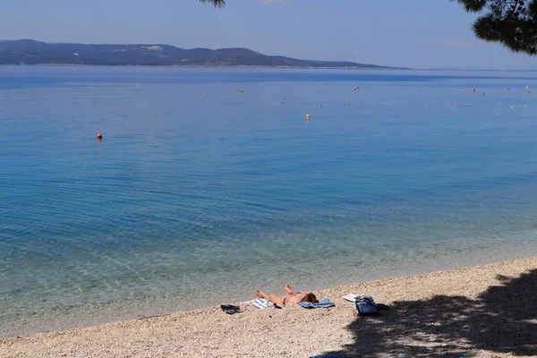 Makarska, Hırvatistan, 12,05,2022. Turistler deniz kıyısındaki güneşli havanın tadını çıkarırlar.