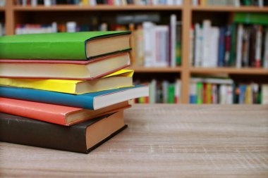 Kütüphanedeki masanın üzerinde kitap yığını
