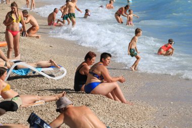 Makarska, Hırvat, 11.07. 2022 yılı. Hırvatistan 'ın güneyinde yer alan Makarska' da bir turizm beldesi olan plajda yüzüyor