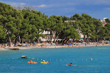 Makarska, Hırvat, 11.07. 2022 yılı. Hırvatistan 'ın güneyinde yer alan Makarska' da bir turizm beldesi olan plajda yüzüyor