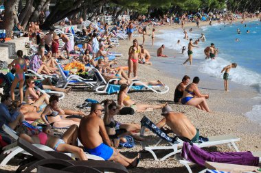 Makarska, Hırvat, 11.07. 2022 yılı. Hırvatistan 'ın güneyinde yer alan Makarska' da bir turizm beldesi olan plajda yüzüyor