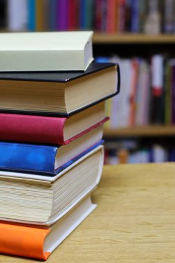 Kütüphanedeki masanın üzerinde kitap yığını