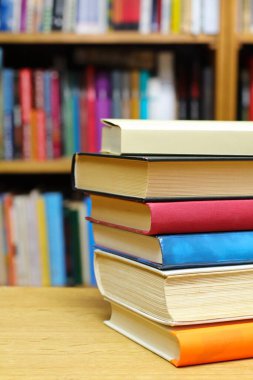 Kütüphanedeki masanın üzerinde kitap yığını