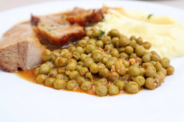 Lezzetli ızgara et, sebzeli ve beyaz tabakta otlar.