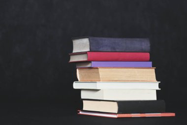 Siyah arkaplan üzerine kitap yığını