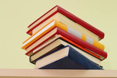 Tahta masadaki kitap yığını.