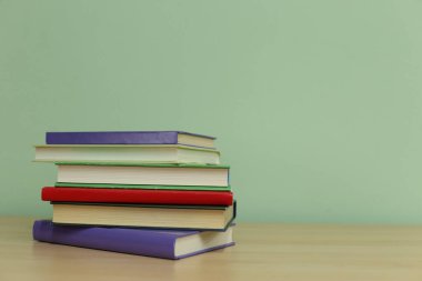 Tahta masadaki kitap yığını.