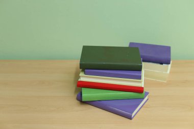 Tahta masadaki kitap yığını.