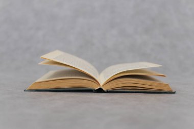 Tahta bir masanın üzerinde açık bir kitap.