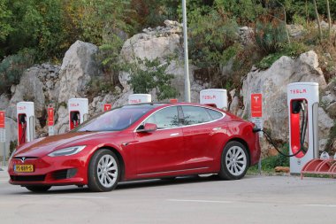 Şehirde kırmızı Tesla arabası