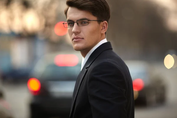 Profile portrait of an adult male model with glasses. Business man wearing black suit, looking at the side. — Stock Photo, Image