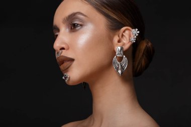 Makyajlı seksi kadın yüzünün yakın plan profil portresi, aksesuar takın, izole edilmiş siyah arka plan.