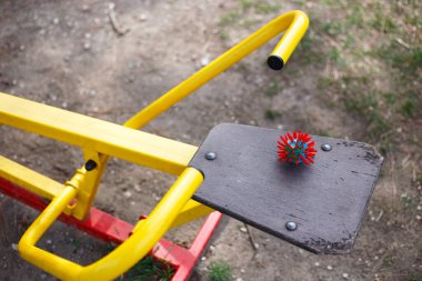 Plasticine 'den Coronavirus sembolü Covid-19 oyun parkındaki bir eğitim cihazına yerleştirilmiş. Enfeksiyon tehlikesi, enfeksiyonu önlemek için koruma.