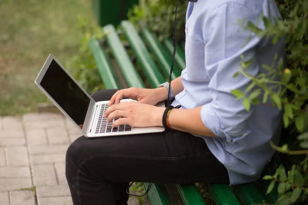 Laptop Kullanan Kulaklıkla Müzik Dinleyen Şehir Parkındaki Bankta Oturan Bir — Stok fotoğraf