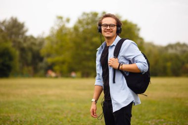 Portatif, kulaklıklı ve gözlüklü genç bir öğrenci. Eğitici kavram.