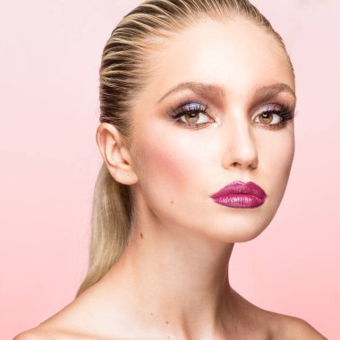 Güzel makyajlı, saçı düzleştirilmiş ve arka planda tutulmuş, izole pembe bir kadın portresi..