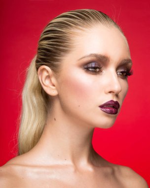 Çıplak omuzlu mükemmel makyajlı, kırmızı arka planda izole edilmiş genç bir kadın modelin portresi. Güzel portre..