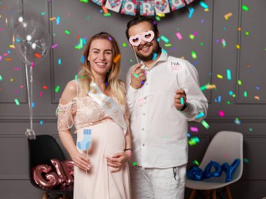 Cinsiyet ayrımcılığı sırasında balon tutan mutlu çift konfeti ve balon eşliğinde parti veriyor..