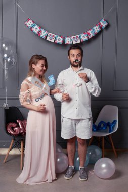 Cinsiyet ayrımcılığı sırasında elinde yazıtlarla dolaşan mutlu bir çiftin uzun bir görüntüsü konfeti ve balonların üzerindeki partiyi gözler önüne seriyor..