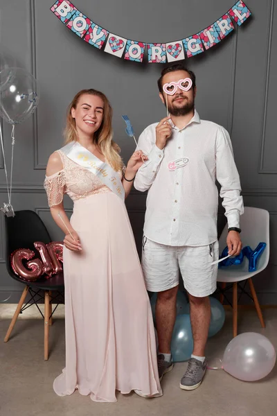 Cinsiyet ayrımcılığı sırasında elinde yazıtlarla dolaşan mutlu bir çiftin uzun bir görüntüsü konfeti ve balonların üzerindeki partiyi gözler önüne seriyor..