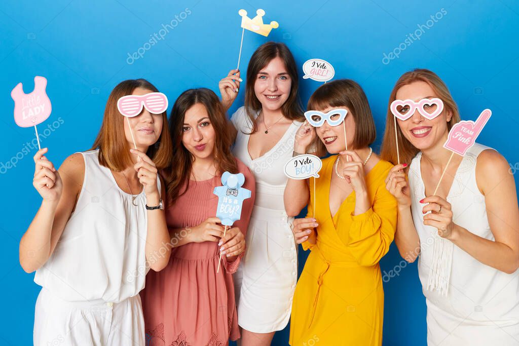 A group of friends happy to have gender reveals envent, isolated blue background.