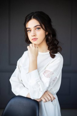 Attractive sexy woman wear white total look. Girl look sexy and happy. Elegant look. Brunette model wear white shirt and jeans. Winter, summer, fall autumn or spring minimal outfit. Focus on finger.