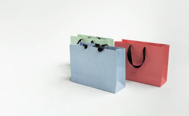 Mock-up of blank craft package, mockup of colored three paper shopping bag with black handles on the white background