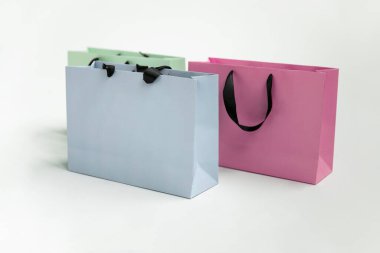 Mock-up of blank craft package, mockup of colored three paper shopping bag with black handles isolated on white background