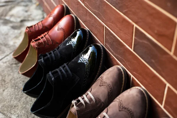 Frontal View Colored Lot Pairs Shoes Arranged Brick Wall Horizontal — Stok fotoğraf