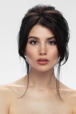 Güzel esmer, çıplak omuzlu ve göz farı makyajlı.