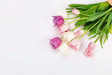 Bouquet of diverse tulips on a white wooden table, copy space. Easter.
