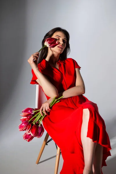 Elegante Morena Sexy Joven Vestido Rojo Sosteniendo Hermoso Tulipanes Rojos — Foto de Stock