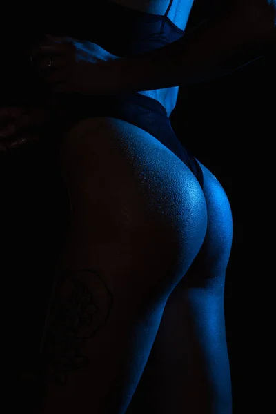 Culotte noire dans le corps des femmes. Modèle de lingerie. Dos sexy en lingerie noire. Une femme sexy tire un caleçon. Lumière au néon — Photo