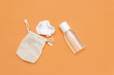 Beyaz doğal makyaj temizleme seti. Yeniden kullanılabilir çevre dostu süngerler ve bej arka planda bir şişe mikiler suyu. Yerleşim planı. Üst Manzara. Boşluğu kopyala.