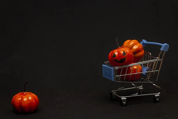 Orangefarbene Kürbisse Einem Einkaufswagen Und Verstreute Kürbisse Auf Schwarzem Hintergrund Stockfoto