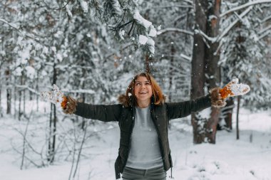 Arkaplanda beyaz kar atan mutlu bir genç kızın bulanık görüntüsü var. Noel tatili, kış tatili.