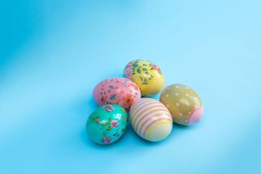 Filmdeki parlak renkli yumurtalar mavi arka planda yatar. Paskalya kartı.