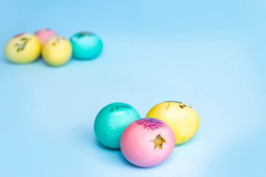 Mavi arka planda parlak renkli Paskalya yumurtaları. Paskalya.