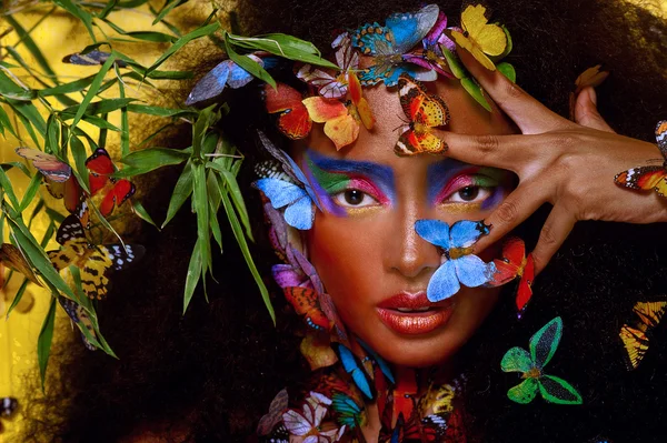 Kelebekler tarafından çevrili güzel bir Afrikalı kız