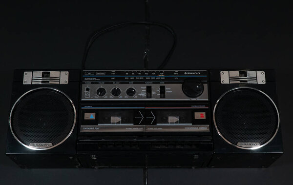 An old, black stereo radio on a black background