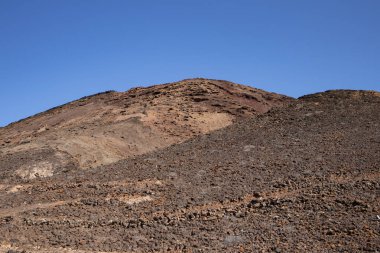 Sabah güneşinde lav dağı. Parlak mavi gökyüzü. Monatna Roja, Playa Blanca, Lanzarote, Las Palmas, Kanarya Adaları, İspanya.