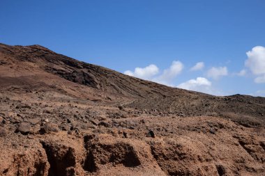 Sabah güneşinde lav dağı. Parlak mavi gökyüzü. Monatna Roja, Playa Blanca, Lanzarote, Las Palmas, Kanarya Adaları, İspanya.