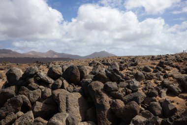 Volkanik kaya ve taşlar, koyu kahverengiden siyaha boyanmış, tüm adayı kaplıyor. Playa Blanca, Lanzarote, Kanarya Adaları, İspanya.