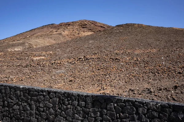 Sabah güneşinde lav dağı. Parlak mavi gökyüzü. Monatna Roja, Playa Blanca, Lanzarote, Las Palmas, Kanarya Adaları, İspanya.