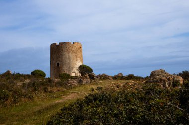 Sardinya 'nın güneyinde yer alan Torre di Pixinni adlı antik taş kulenin kalıntıları, Domus de Maria. Baharda bulutlu bir gün. Akdeniz adası Sardunya, İtalya.